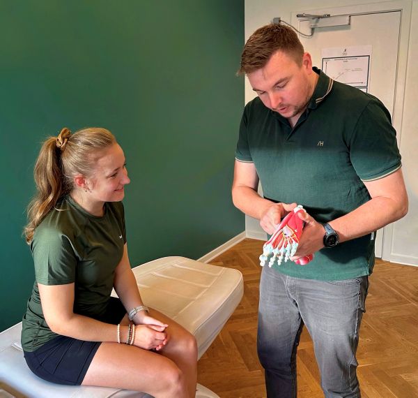 Fysioterapeut viser bevægelser i foden på en fodmodel